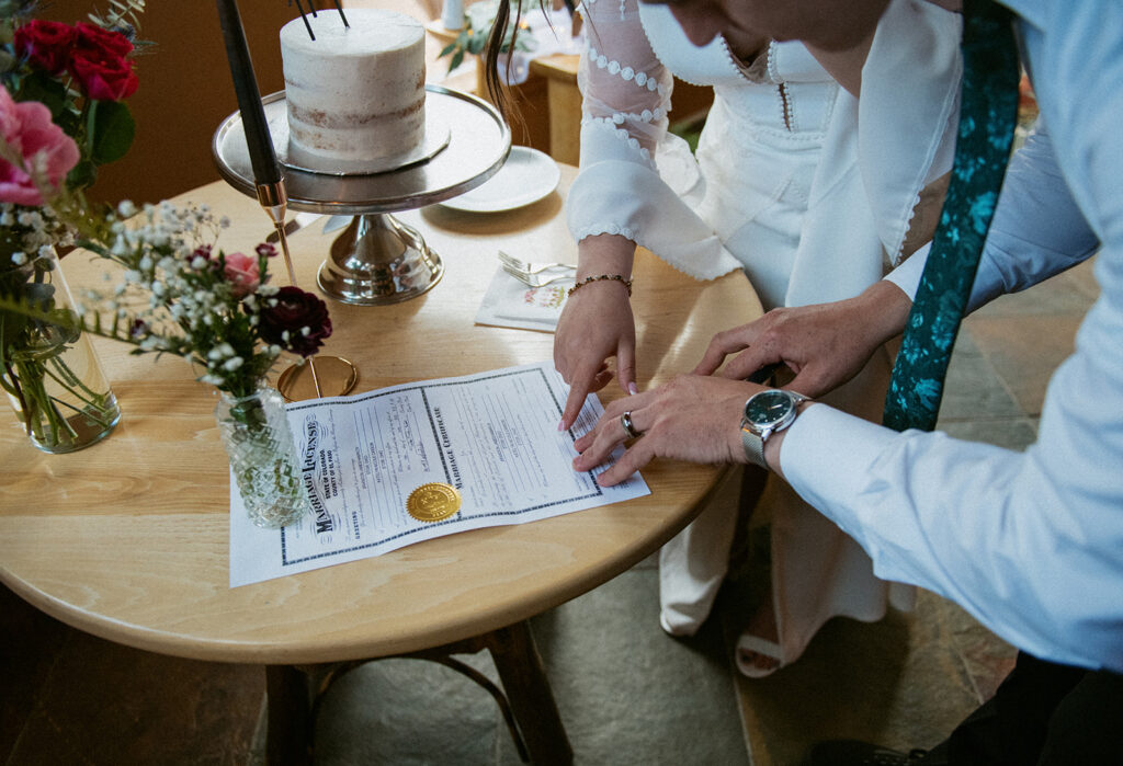 A couple signing their Colorado marriage license