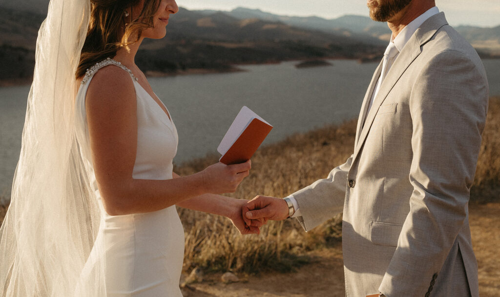 A couple exchanging vows by a lake in Colorado