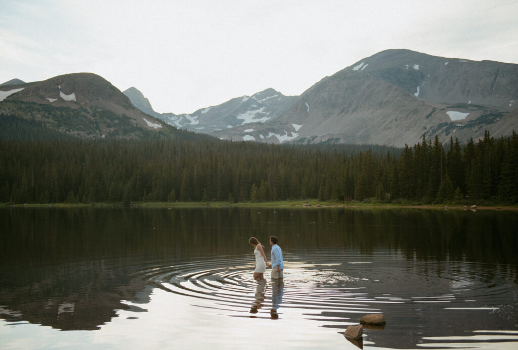 A couple walking together through Brainard Lake during their engagement session