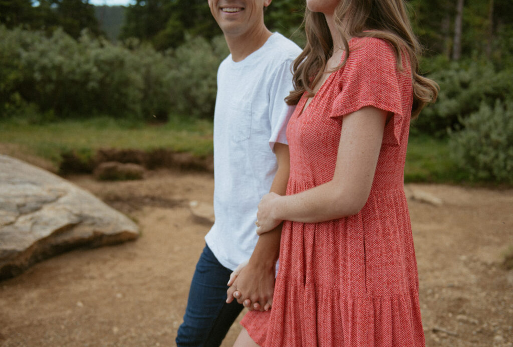 A couple smiling while walking arm in arm during their engagement session