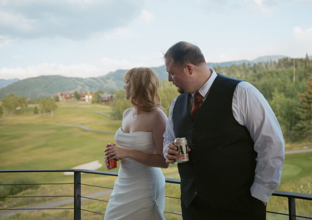 couple watches the sunset on the balcony of their airbnb wedding venue in colorado