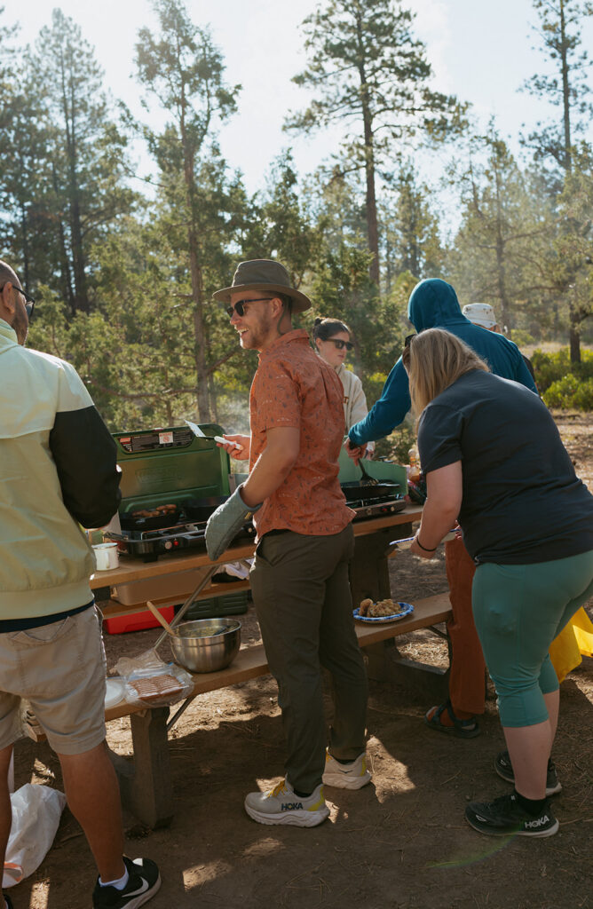a couple makes breakfast at a campsite on their wedding morning
